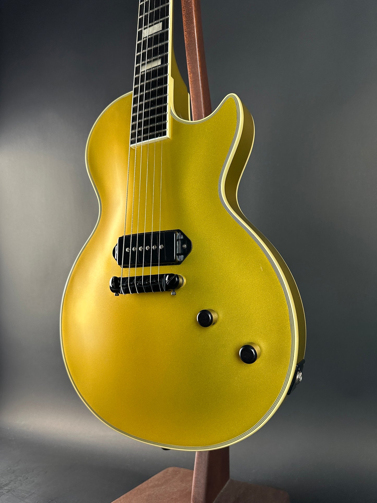 Gold electric guitar on a gray background