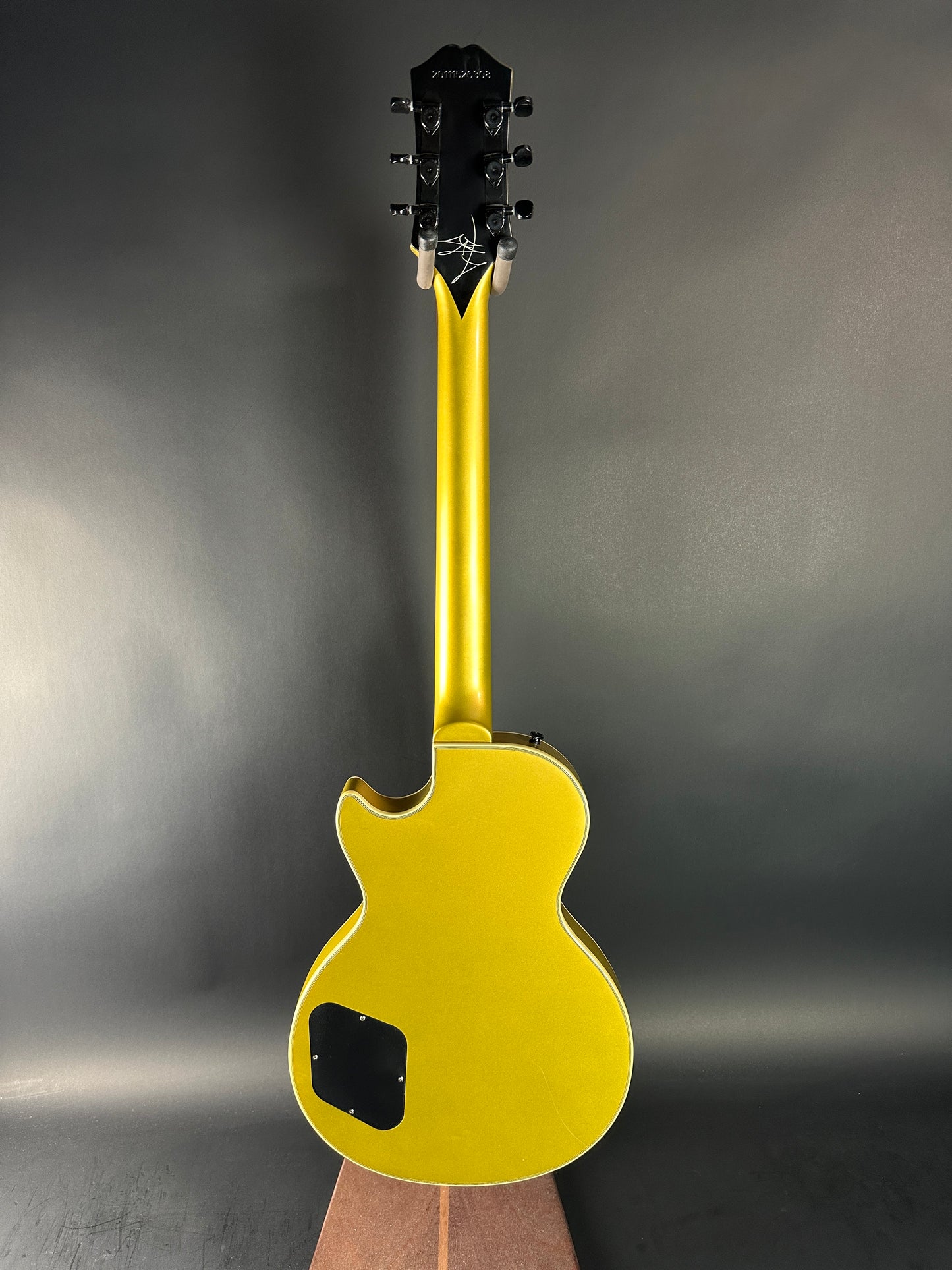 Yellow electric guitar on a dark gray background