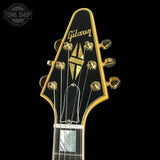 Gibson guitar headstock with gold tuning pegs on a black background