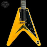 Yellow electric guitar with a black pickguard on a black background, featuring 'Tone Shop' branding.