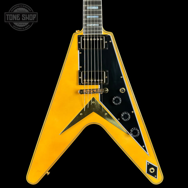 Yellow electric guitar with a black pickguard on a black background, featuring 'Tone Shop' branding.