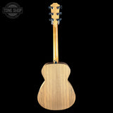 The back view of a wooden acoustic guitar against a solid black background, featuring a natural light wood finish and a Tune Shop watermark in the top left corner.