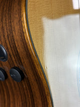 Close-up detail of an electric guitar body showing the glossy maple top, dark wood fingerboard, and black control knobs.