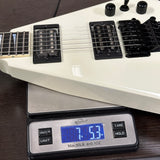 White electric guitar on a digital scale displaying weight
