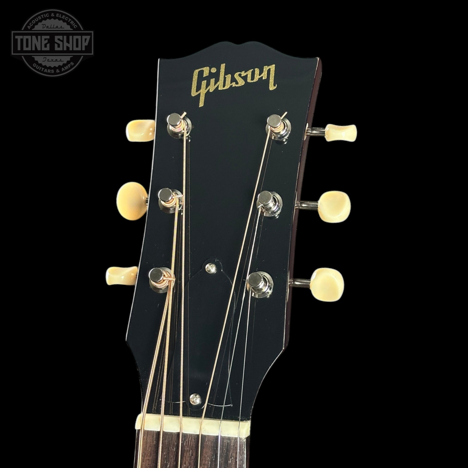 Gibson guitar headstock with tuning pegs on a black background