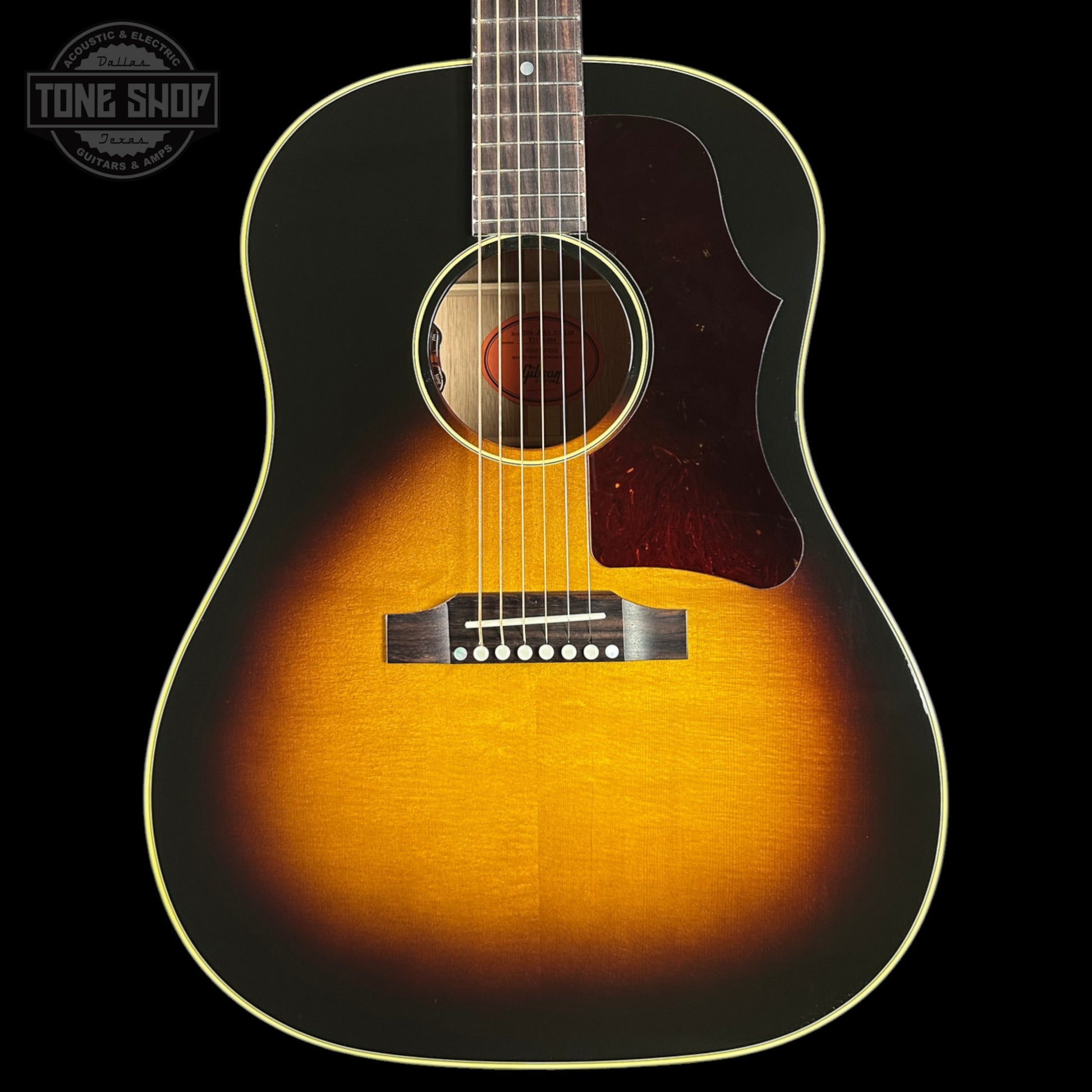 Acoustic guitar with a sunburst finish on a black background, featuring the Tone Shop logo.