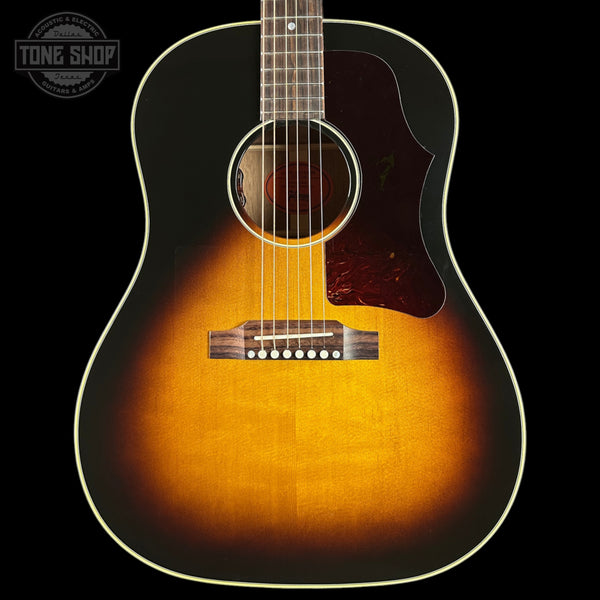 Acoustic guitar with a sunburst finish on a black background, featuring the Tone Shop logo.
