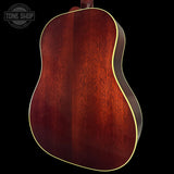 Close-up of a wooden acoustic guitar body with a dark brown finish on a black background.