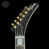 Gibson guitar headstock with gold tuning pegs on a black background
