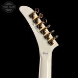Close-up of a white guitar neck with gold tuning pegs on a black background, featuring the Gibson logo.