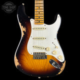 A classic Fender Stratocaster electric guitar with a distressed sunburst finish, featuring a white pickguard, gold-toned hardware, and a maple neck, shown against a solid black background.