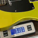 Close-up of a yellow-green electric guitar body resting on a digital scale displaying 7.137 oz.