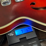 Vintage 1965 Harmony H-78 Red Burst on scale displaying weight.