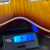 Used 2009 Gibson Les Paul Traditional Desert Burst on scale displaying weight.