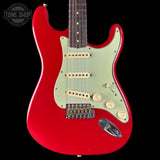 Red electric guitar with a white pickguard on a black background, featuring 'Tone Shop' branding.