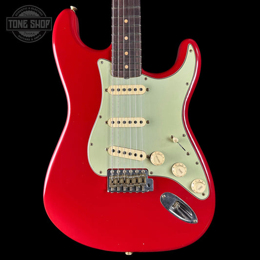 Red electric guitar with a white pickguard on a black background, featuring 'Tone Shop' branding.