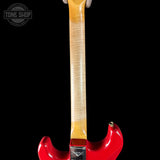 Close-up of a red electric guitar with a visible brand logo on a black background