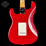 Red electric guitar with a visible brand logo on a black background