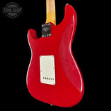 Red electric guitar body with a visible brand logo on a black background