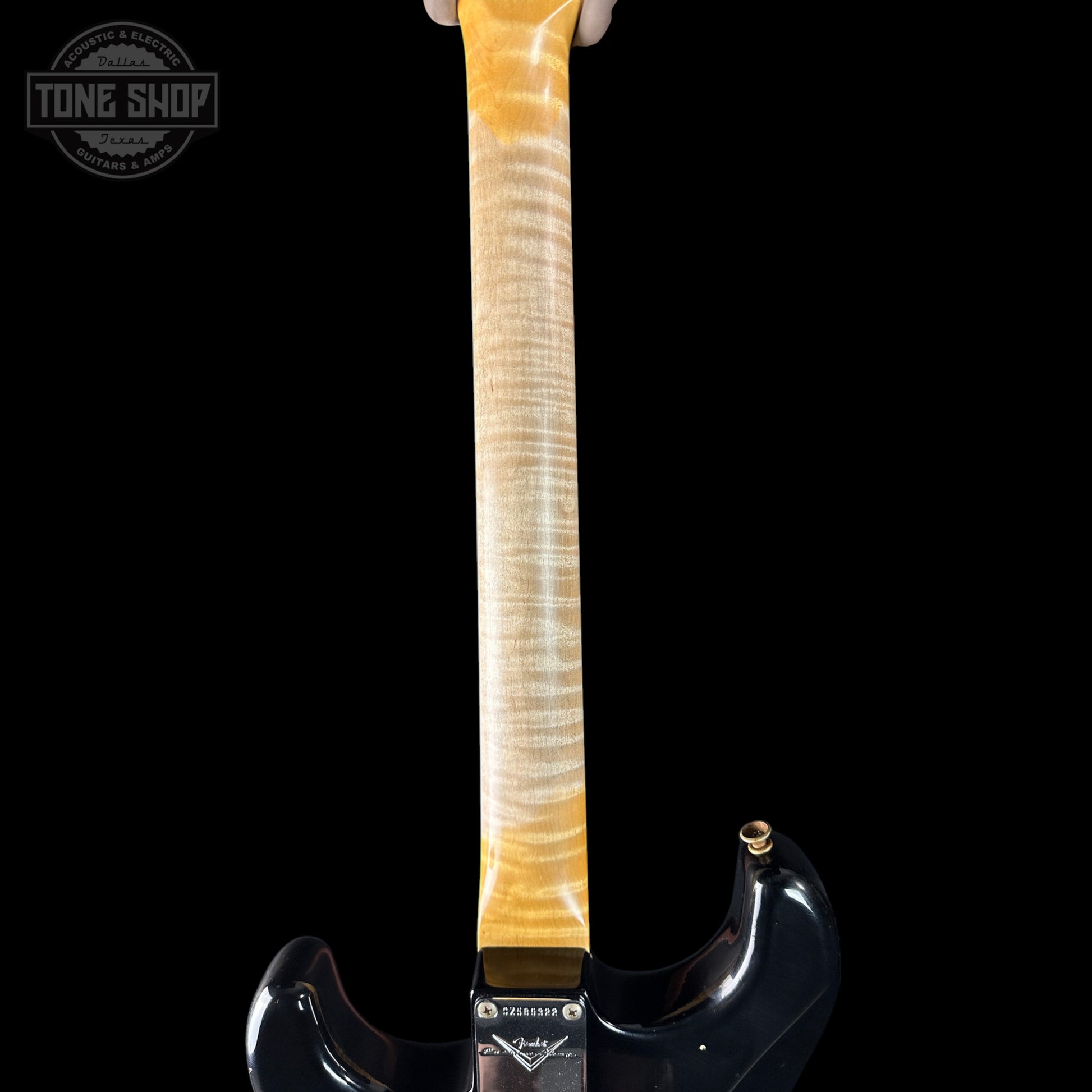 Guitar neck with a black body on a black background, featuring the 'Tone Shop' logo.