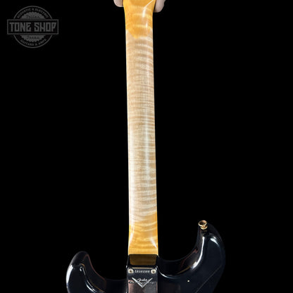 Guitar neck with a black body on a black background, featuring the 'Tone Shop' logo.