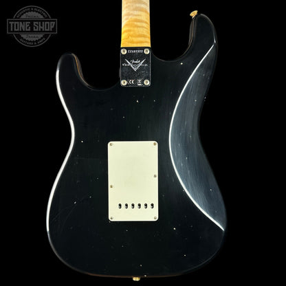 Black electric guitar with a visible Fender logo on a black background
