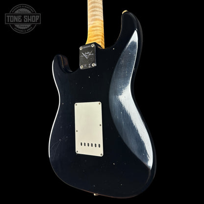 Black electric guitar with a visible brand logo on a black background