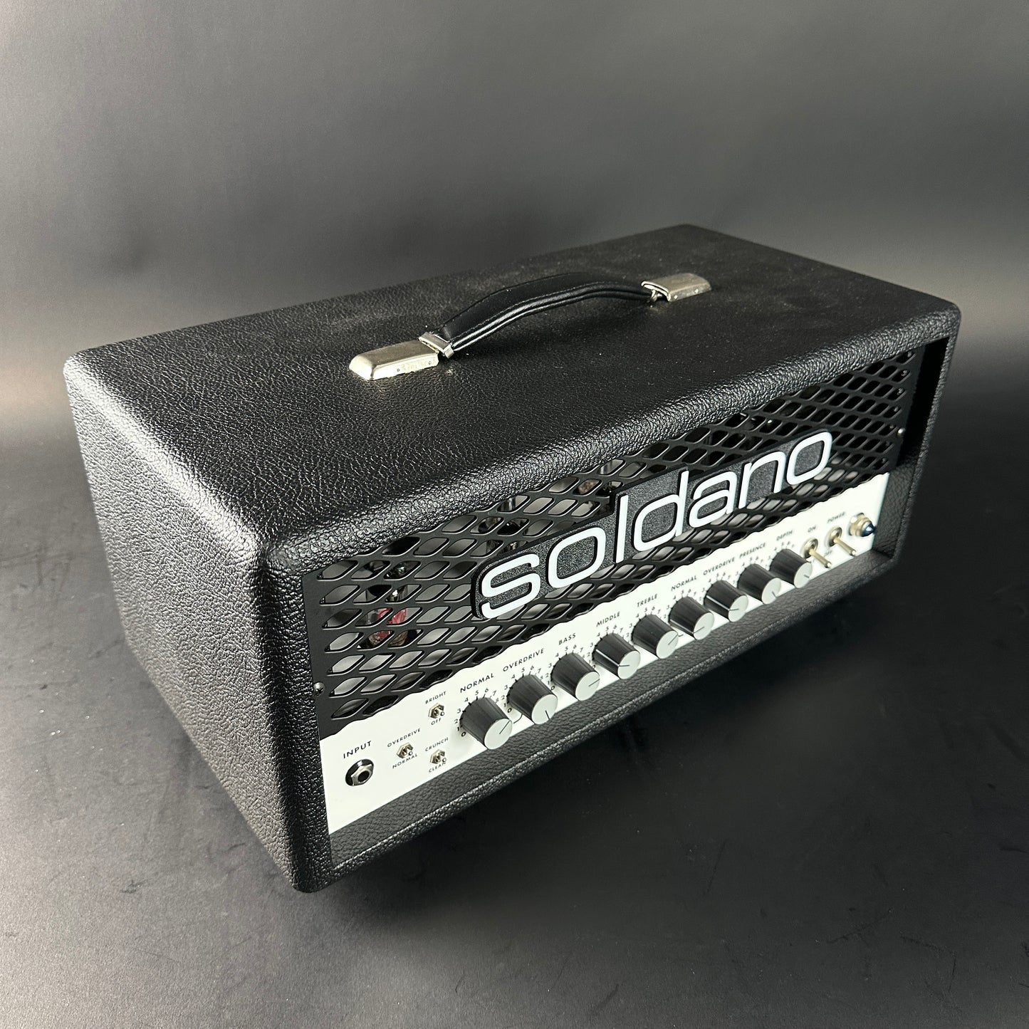 Black Soldano guitar amplifier head on a gray background