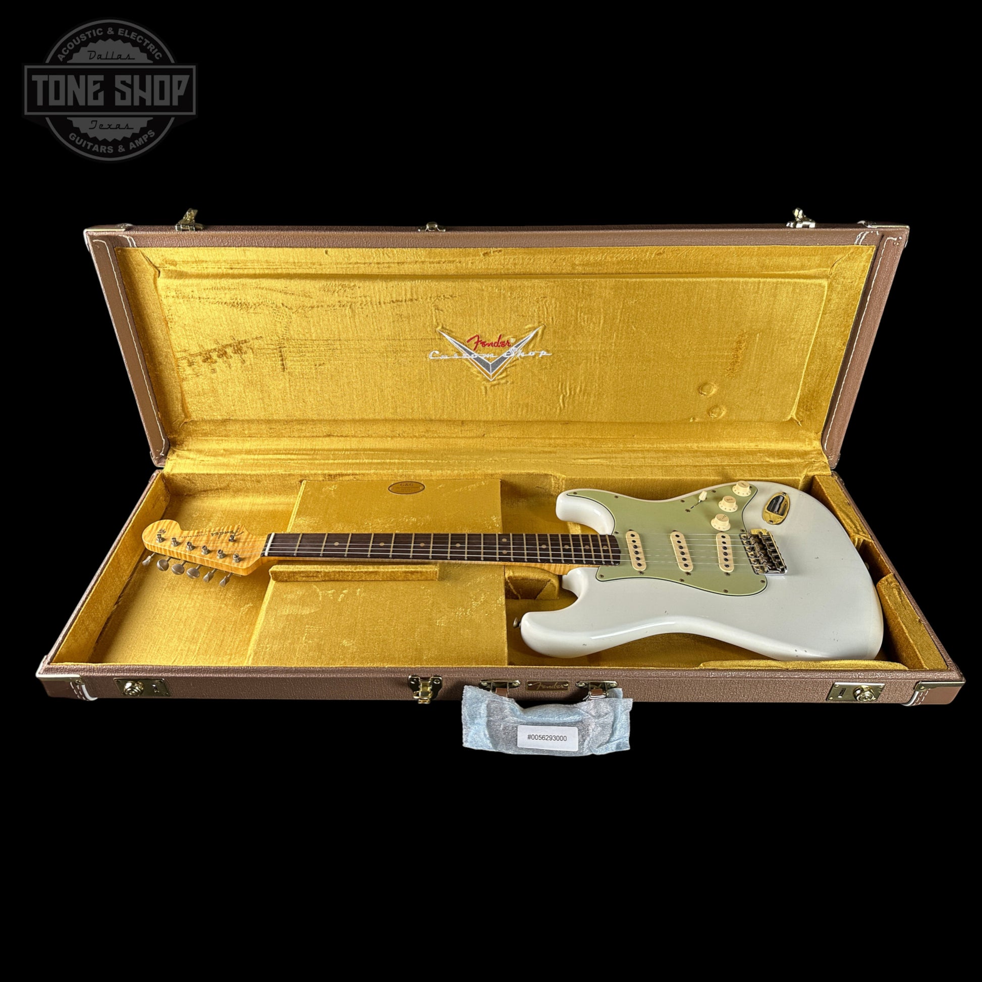Fender electric guitar in a gold case with 'Tone Shop' logo.