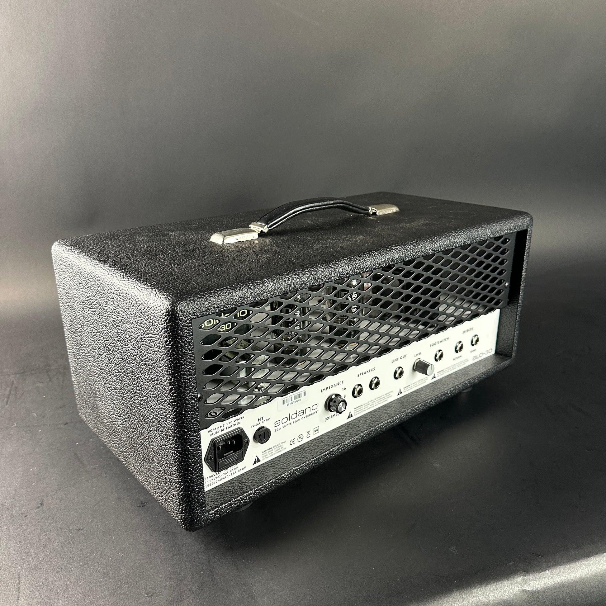 Black guitar amplifier head on a gray background