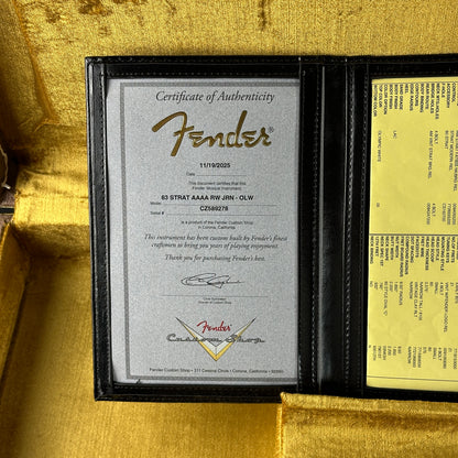 Fender certificate of authenticity inside a guitar case with gold interior.