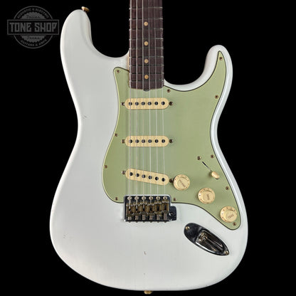 White electric guitar with green pickguard on a black background, featuring 'Tone Shop' branding.