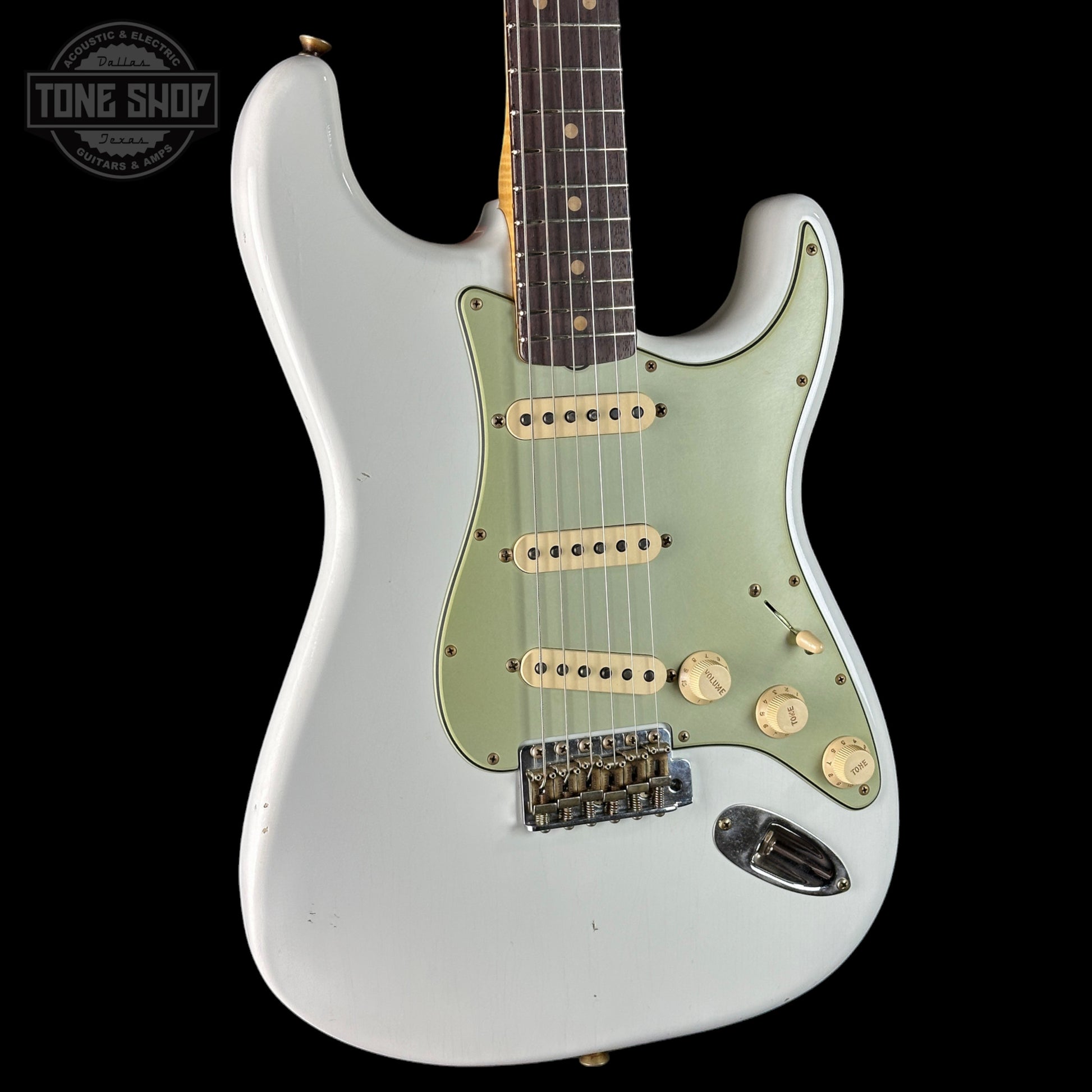 White electric guitar with a visible brand logo on a black background