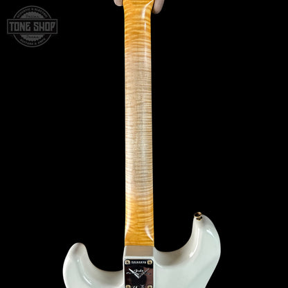 Close-up of a white electric guitar with a wooden neck on a black background, featuring 'Tone Shop' branding.
