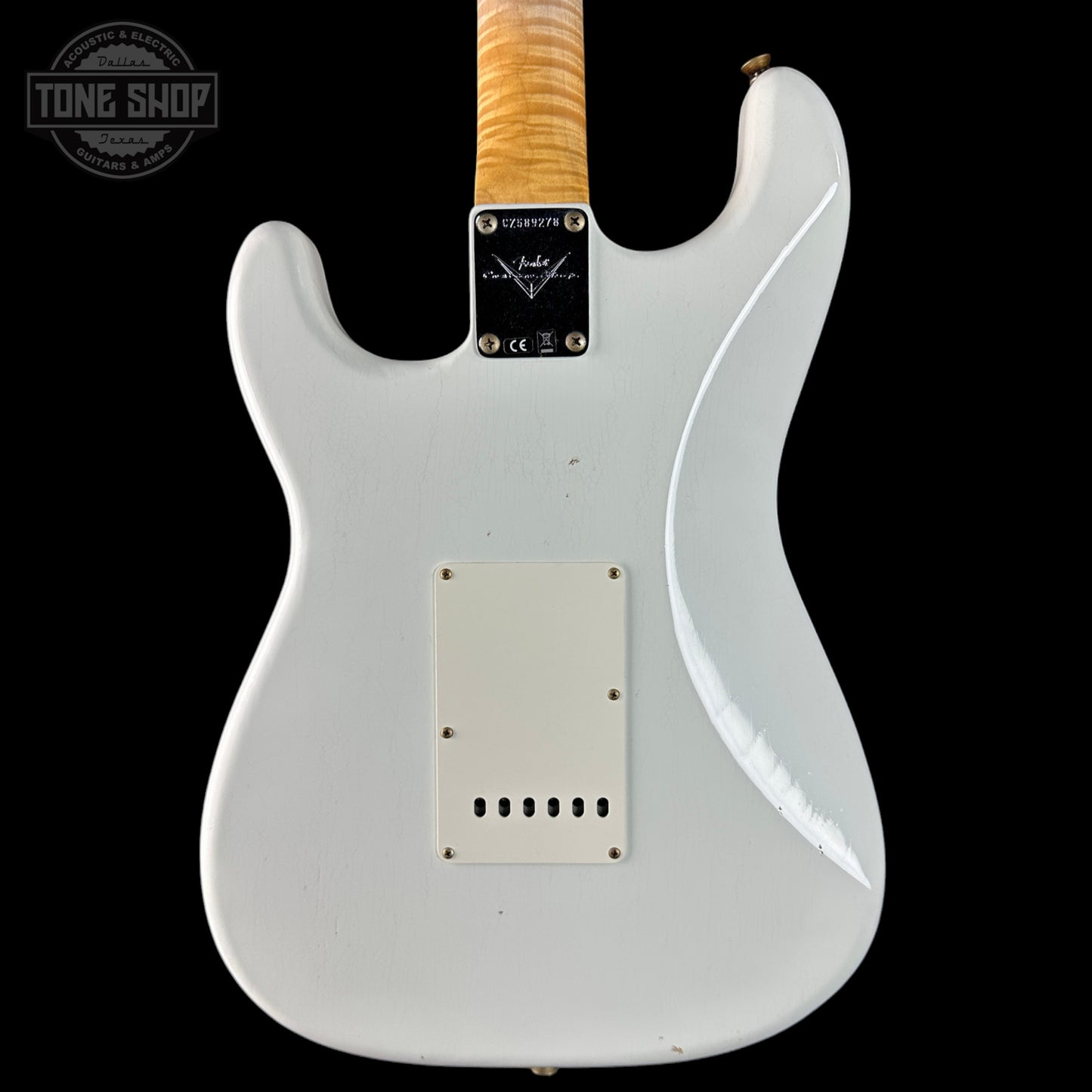 White electric guitar with a visible brand logo on a black background