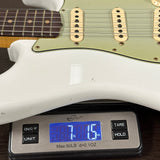 Guitar being weighed on a digital scale with a visible weight reading.
