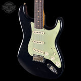 Black electric guitar with a white pickguard on a black background, featuring the Tone Shop logo.