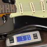 Electric guitar on a digital scale displaying weight
