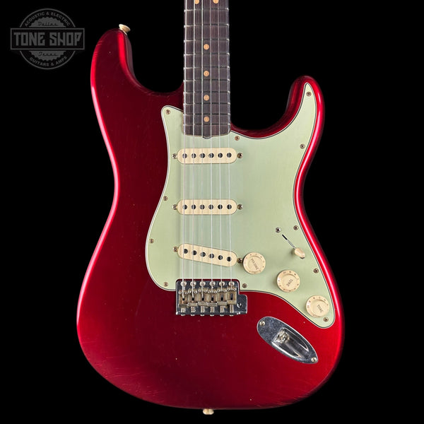 Red electric guitar with a white pickguard on a black background, featuring 'Tone Shop' branding.