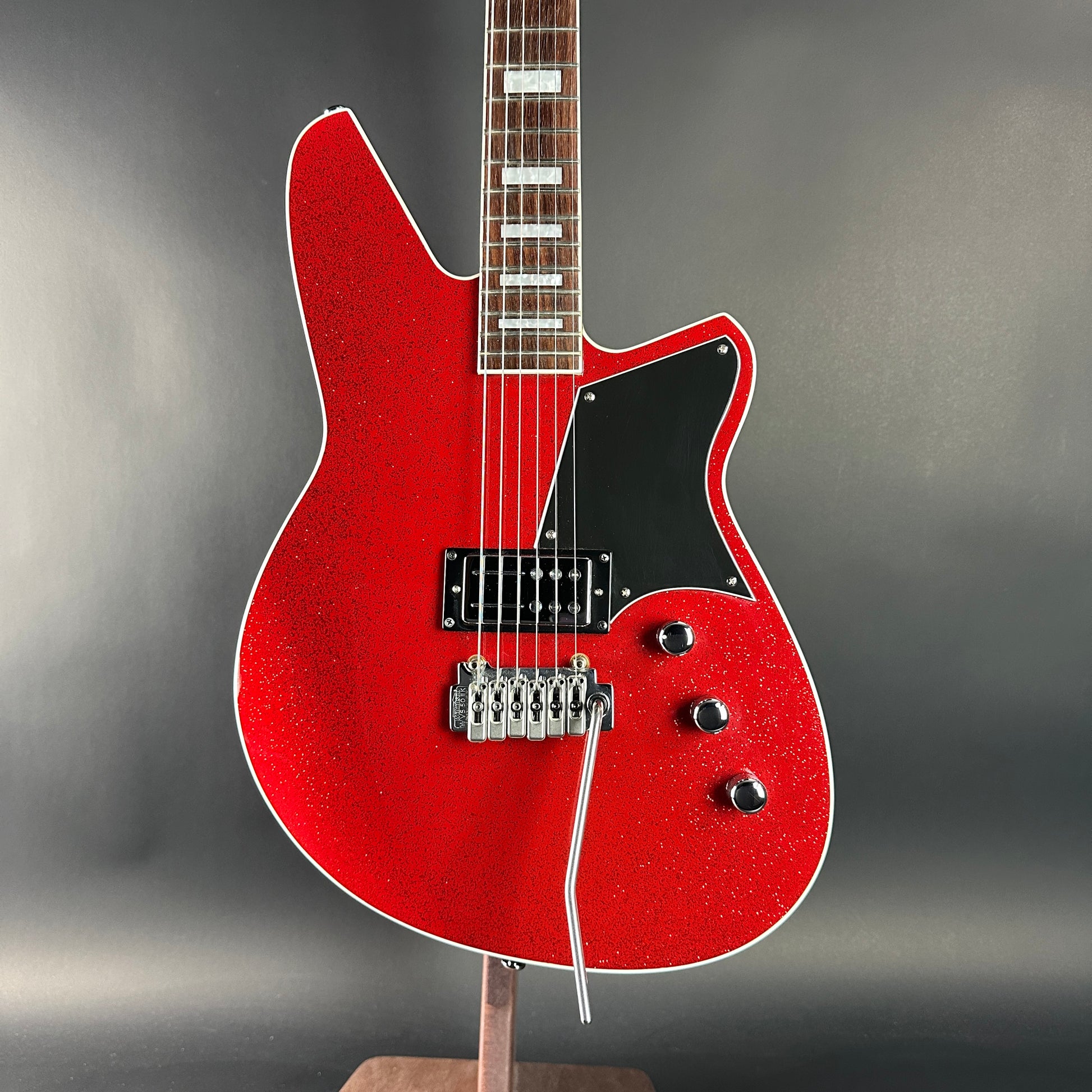 Red electric guitar on a gray background