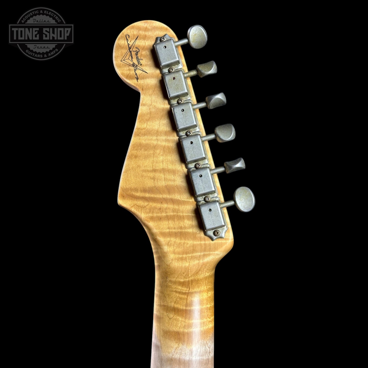 Guitar headstock with tuning pegs on a black background, featuring the Tone Shop logo.