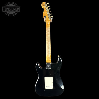 Black electric guitar with a visible brand logo on a black background