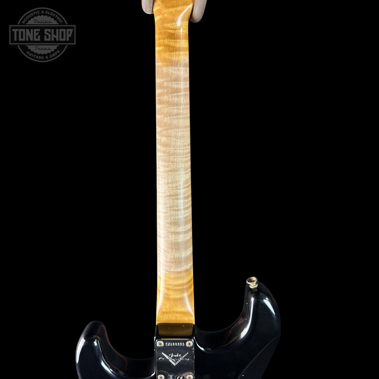 Guitar neck with a black body on a white background, featuring the Tone Shop logo.