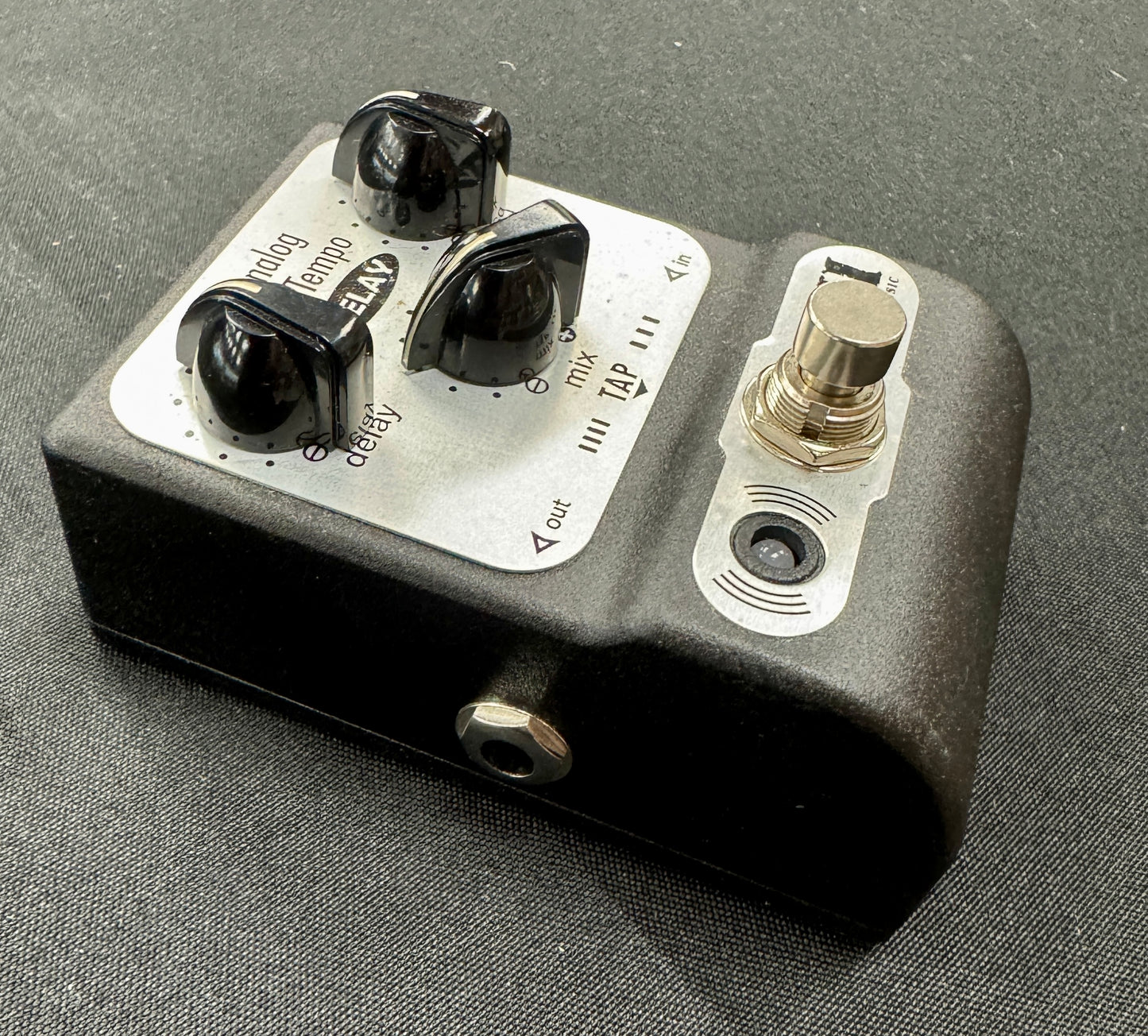 Guitar effects pedal with knobs and switches on a gray background