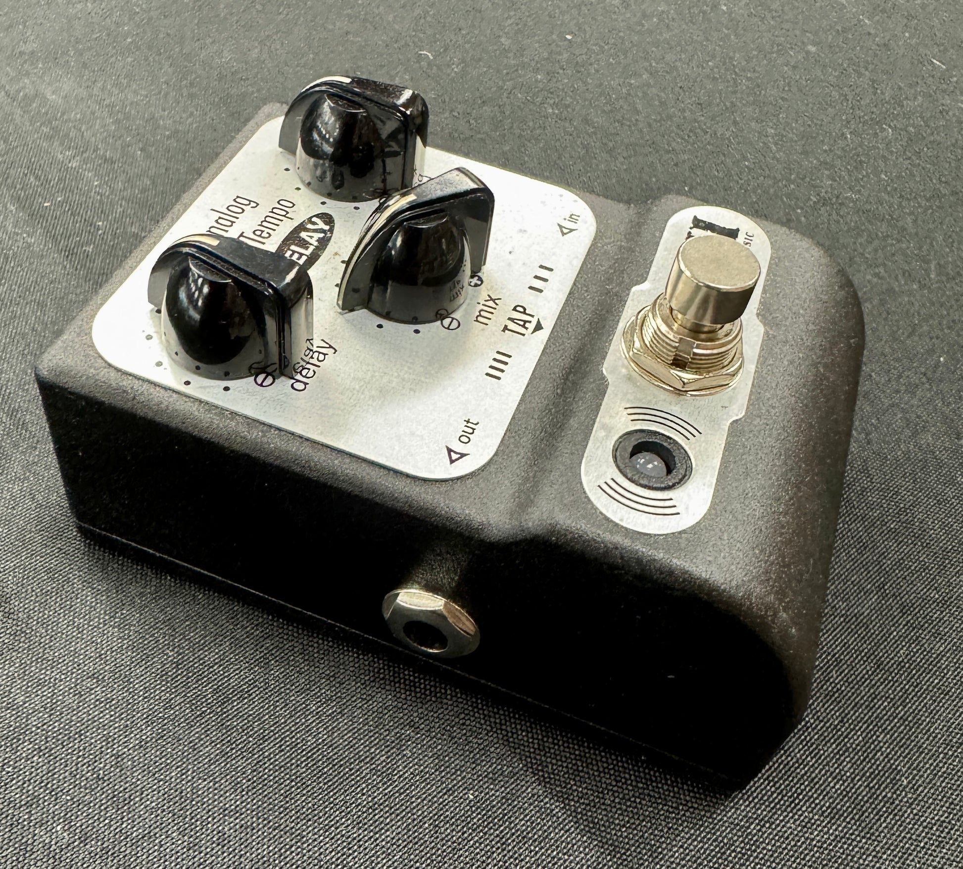 Guitar effects pedal with knobs and switches on a gray background