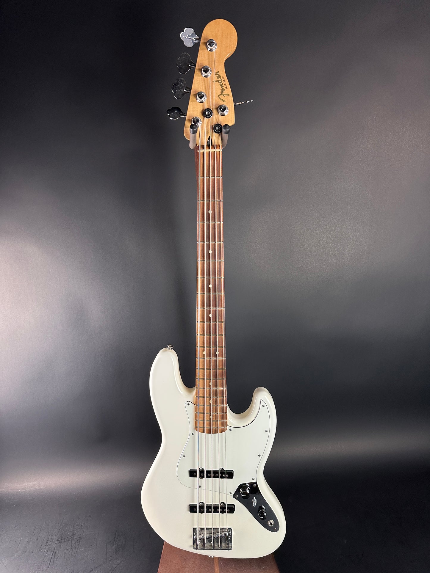 White electric bass guitar on a dark gray background