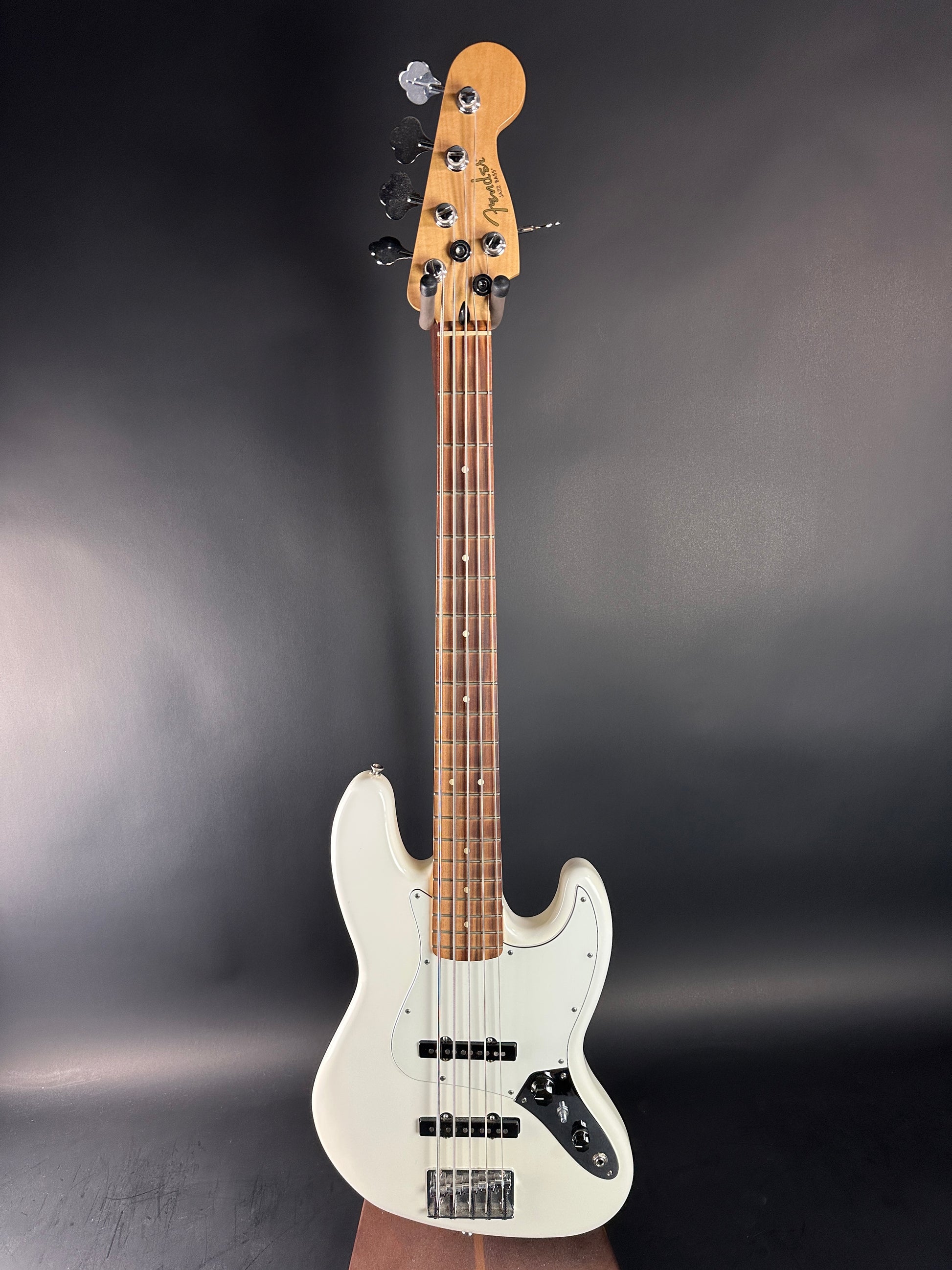 White electric bass guitar on a dark gray background