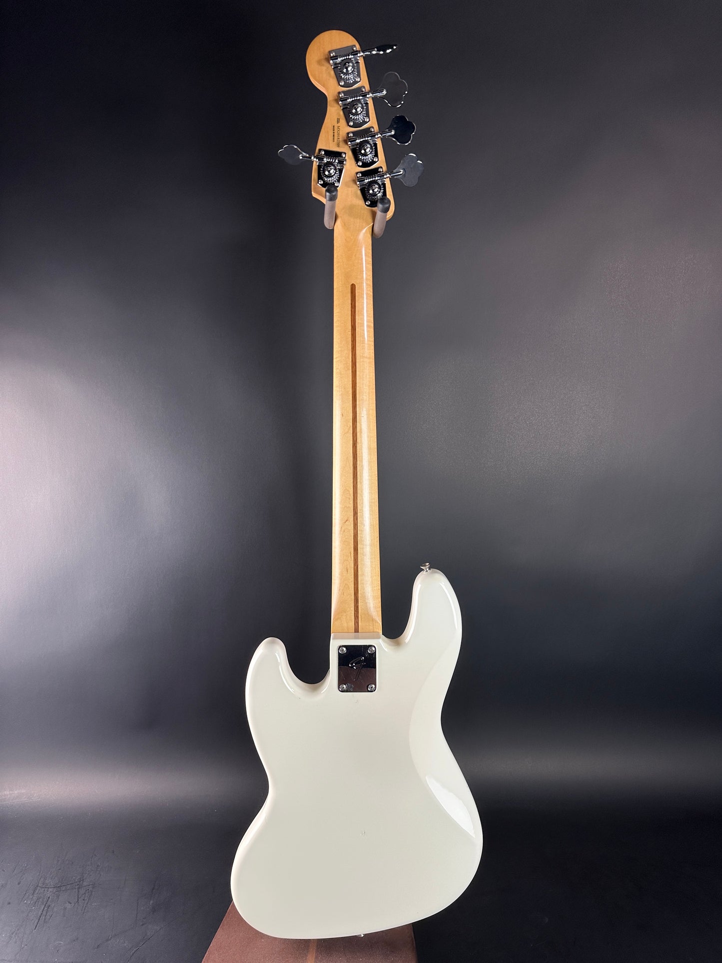 White electric bass guitar on a dark gray background