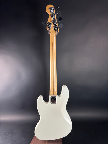 White electric bass guitar on a dark gray background
