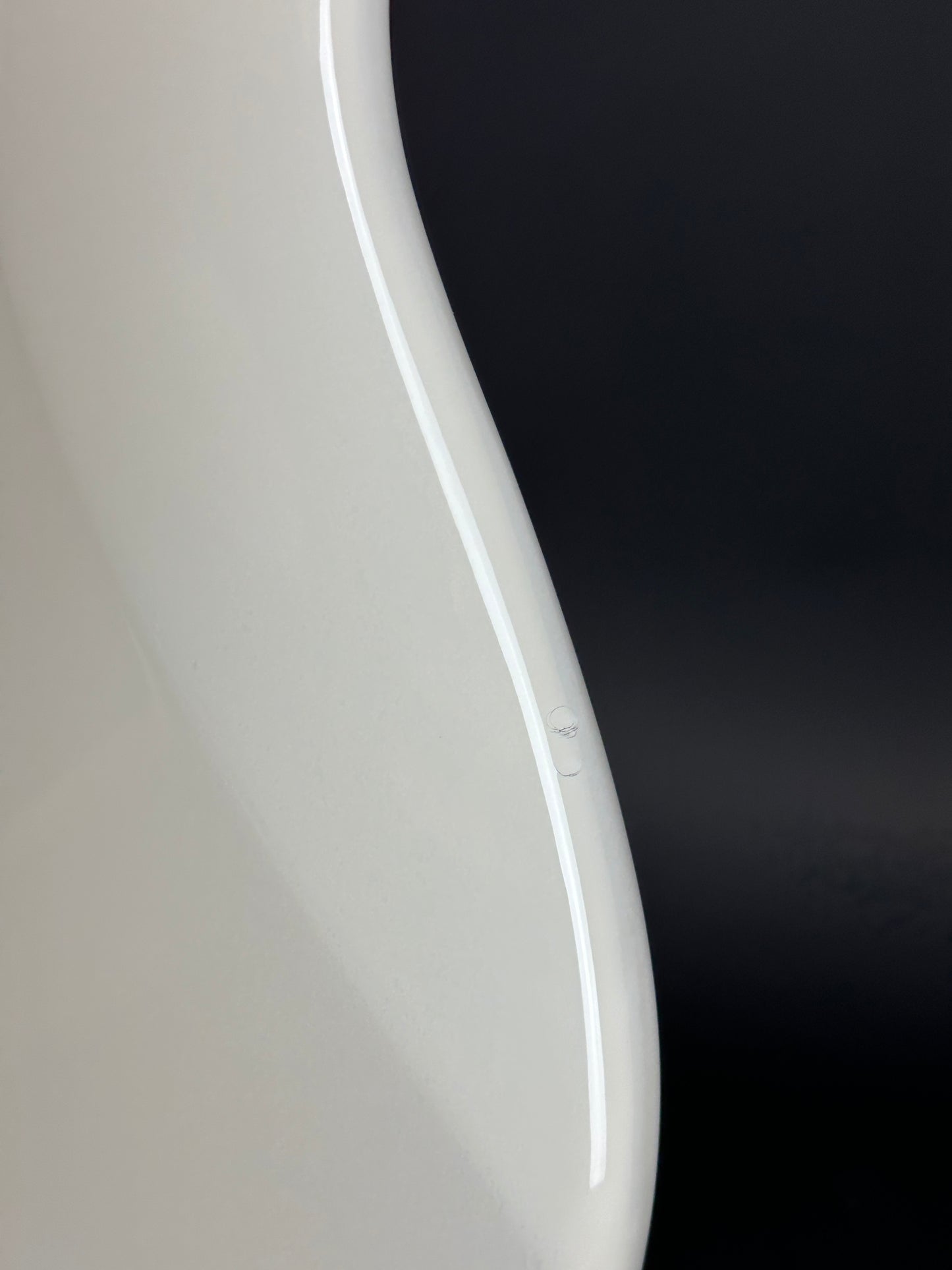 Close-up of a white curved object with a black background
